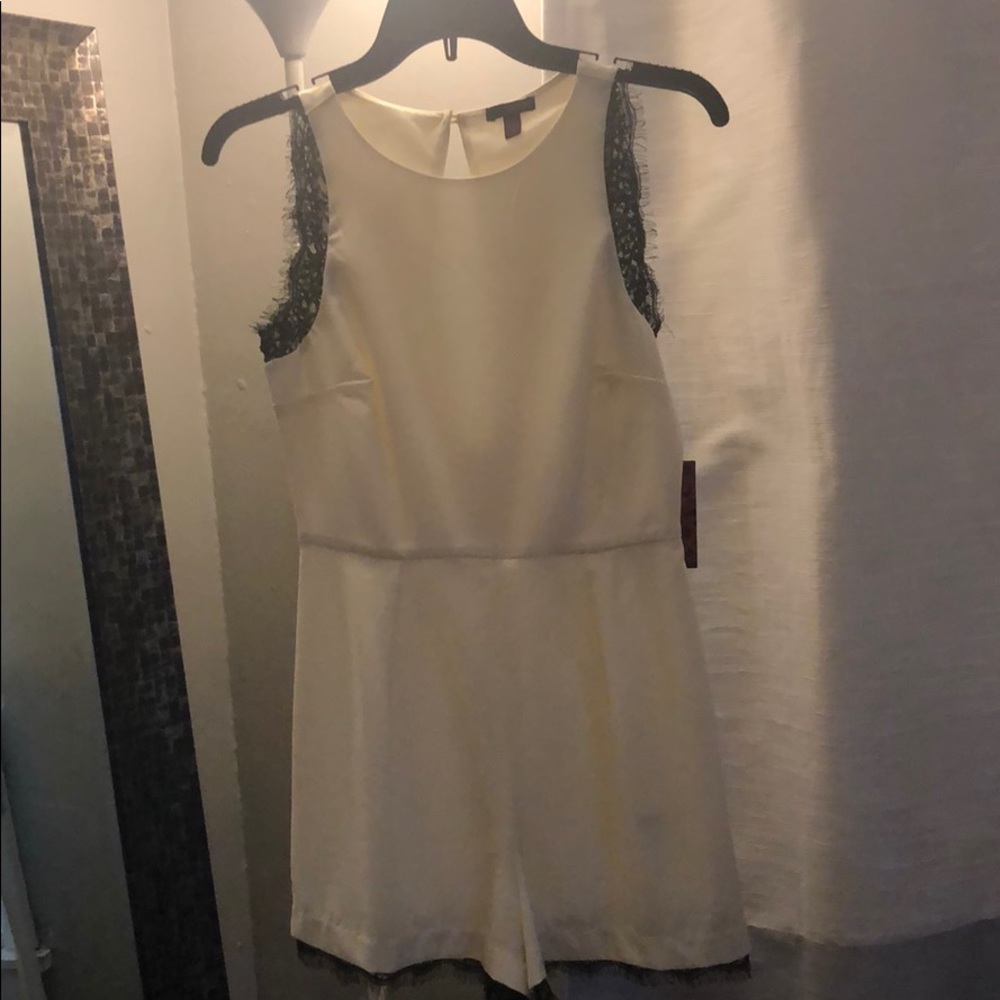 White romper with black lace trimming.